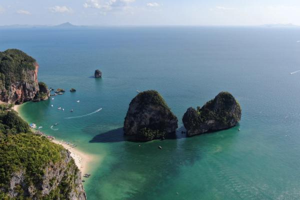 Yacht docked at marina with city skyline.
