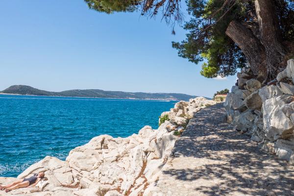 Sailboat rigging with ropes and sails against blue sky.