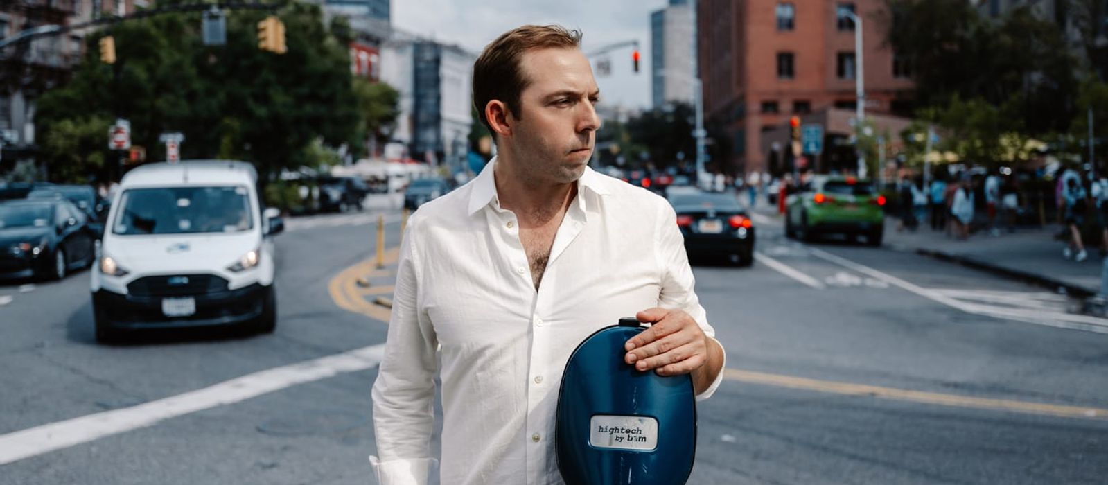 Brook Speltz on a New York City street, white shirt, with cello case