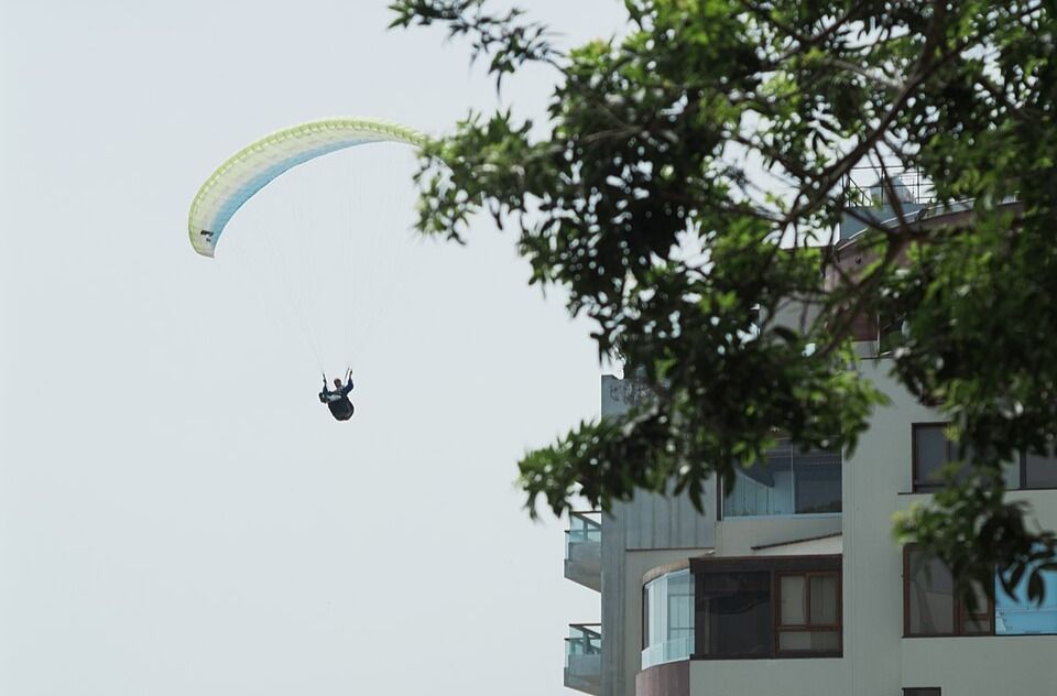 Parapentiste survolant un immeuble résidentiel
