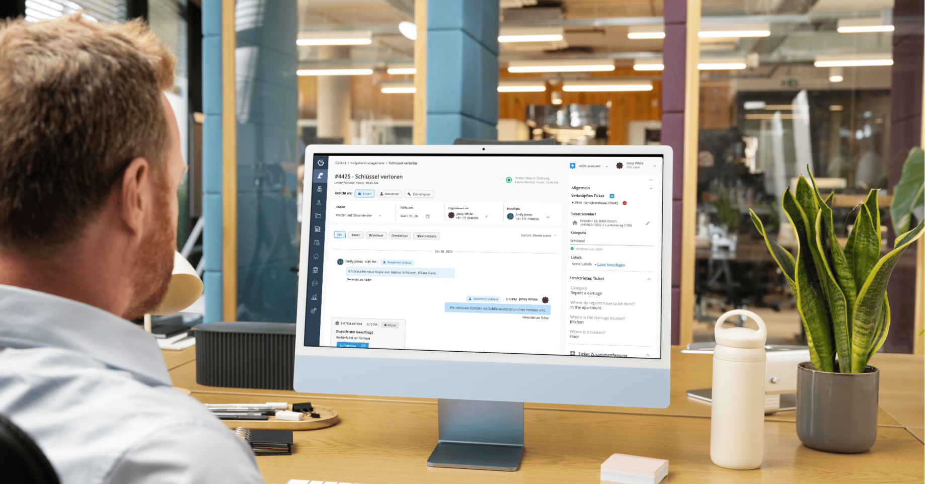 Employé devant un écran avec la plateforme Allthings dans un open space
