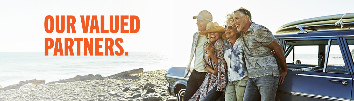 This header image includes a group of friends leaning against a car. The text reads "Our Valued Partners".