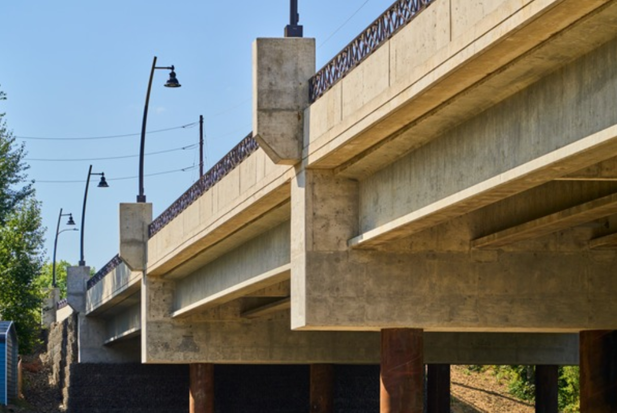 A low-angle view of the Boeckman bridge with streetlights and a railing.