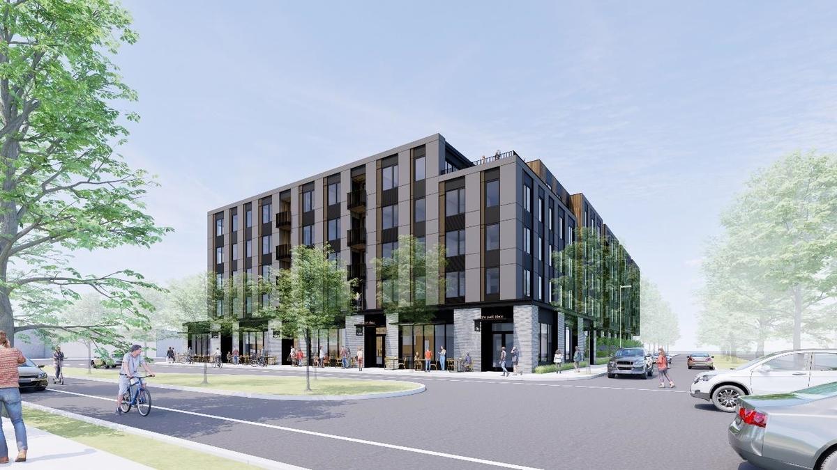 A modern mixed-use building with ground-floor shops and balconies, bordering a street with people, trees, and cars.
