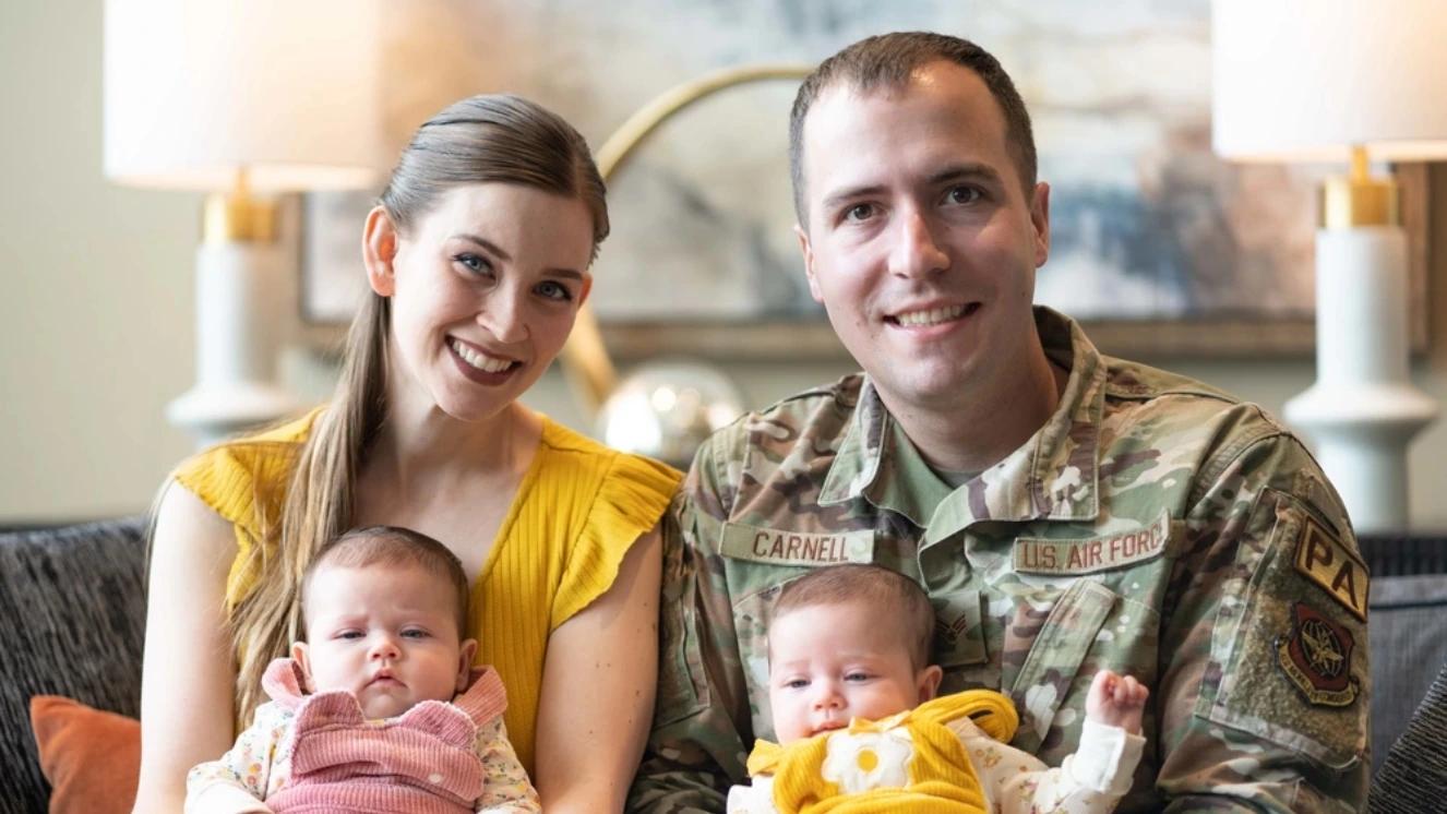 A family sits together on a sofa.