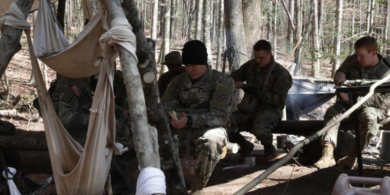 Army flight school students enrolled in the Survival, Evasion, Resistance and Escape course practice crafting tools and weapons during field survival training at Fort Rucker, Alabama, March 1, 2022.
