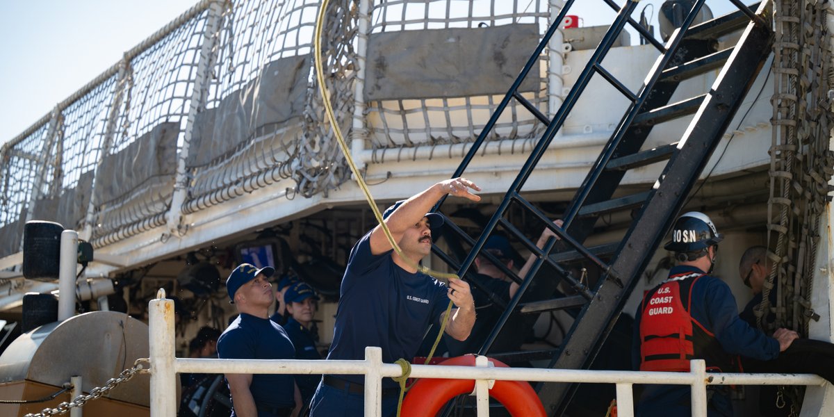 A crew member aboard the national security cutter USCGC Waesche (WMSL 751) throws a heaving line to crew members aboard the USCGC Bertholf (WMSL 750) in Alameda, California.