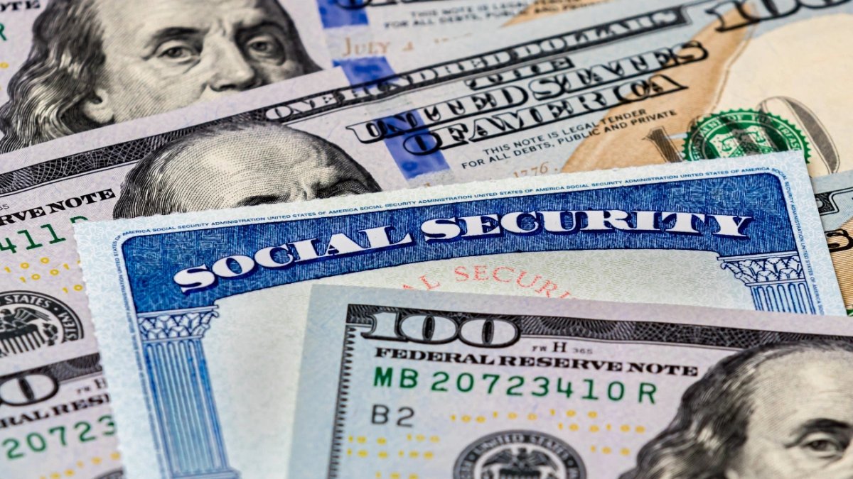 Closeup of social security benefits identification card with 100 dollar bills.