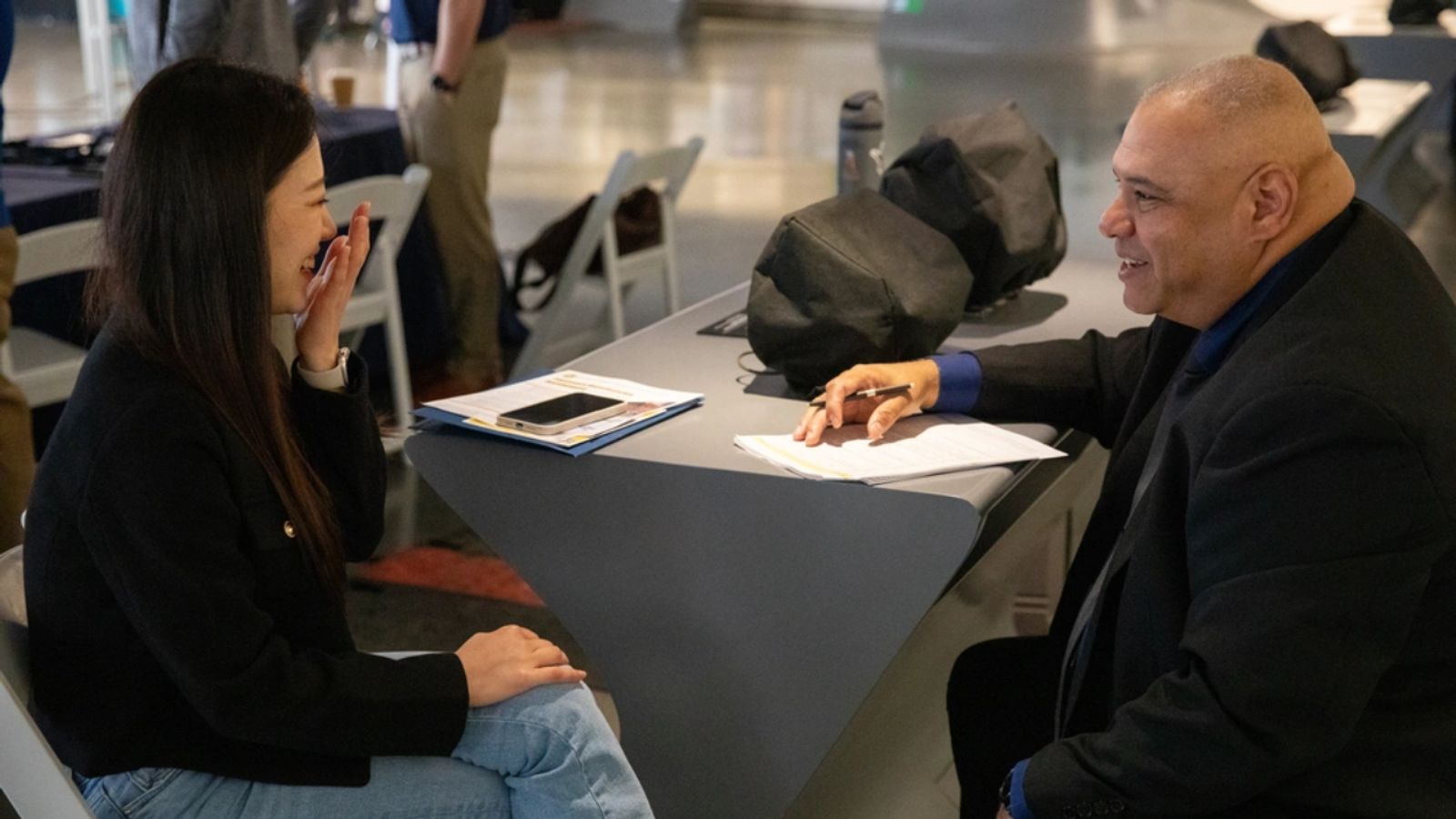 Samuel Chism, right, operations supervisor for the largest Military Entrance Processing Station in the country, conducts a preliminary interview with Saehee Lee, left, a potential hire for a human resources assistant position, during the Total Army Career Fair at SoFi Stadium.