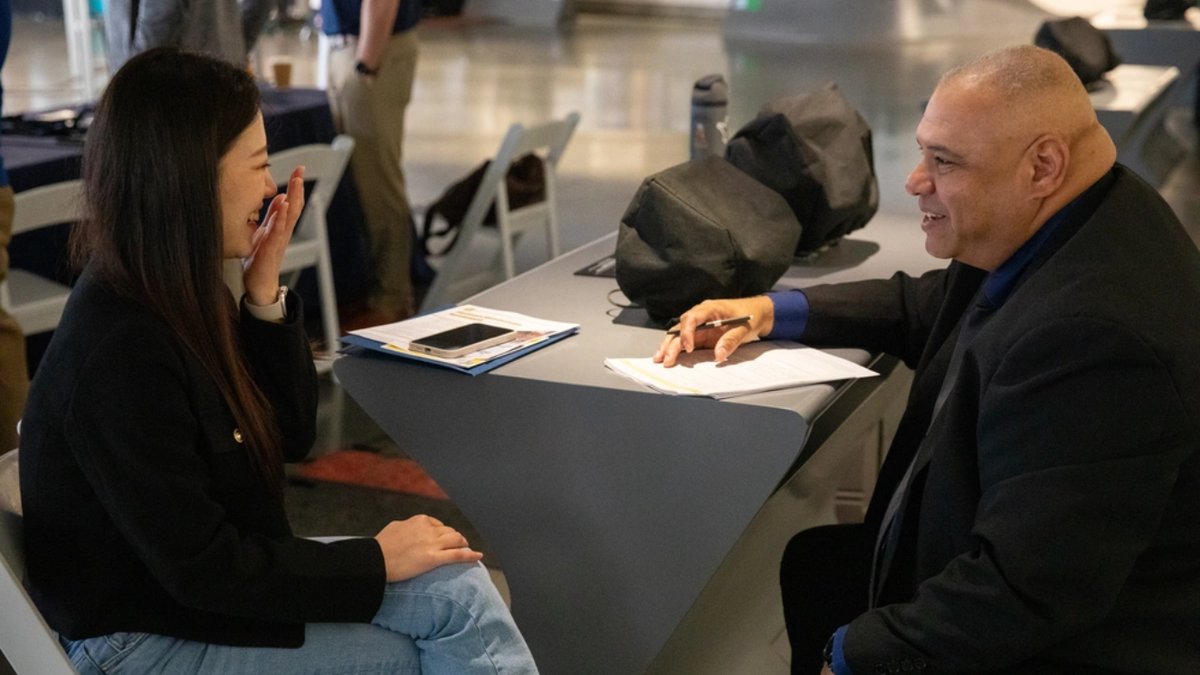 Samuel Chism, right, operations supervisor for the largest Military Entrance Processing Station in the country, conducts a preliminary interview with Saehee Lee, left, a potential hire for a human resources assistant position, during the Total Army Career Fair at SoFi Stadium.