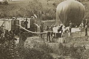 Vintage photo of men blowing up a war balloon
