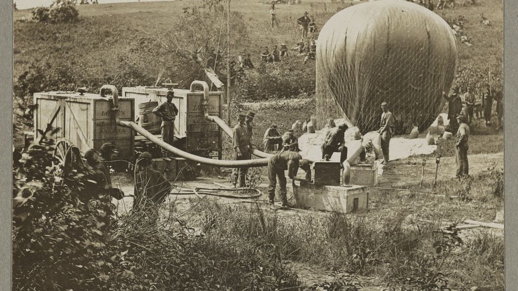 Vintage photo of men blowing up a war balloon