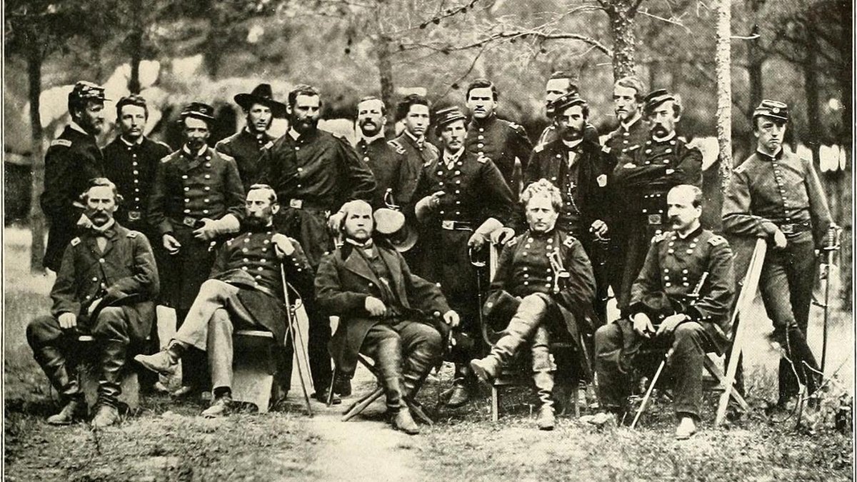 Union Army officers posed in uniform during the Civil War in a wooded area.
