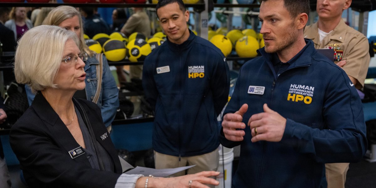 A woman gestures as she speaks to a group of participants in the new Navy initiative.