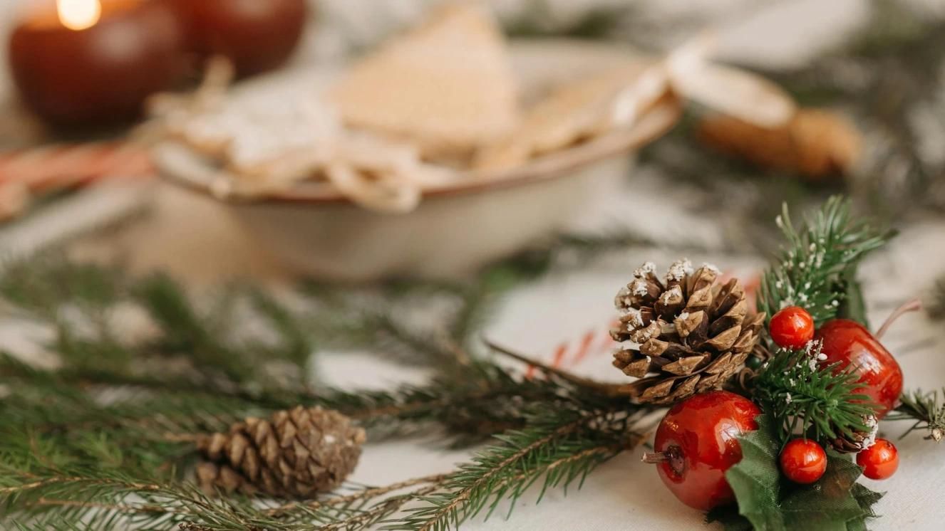 Holiday decorations with pinecones and berries on a table, evoking festive and calming ambiance.