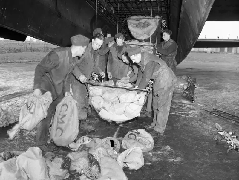 Vintage photo of servicemen uploading food from an airplane.