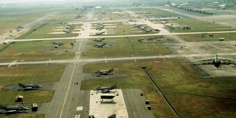An aerial view of Clark Air Base, Luzon, Philippines, on 1 December 1989. Several U.S. Air Force McDonnell Douglas F-4E & F-4G Phantom II aircraft from the 3rd Tactical Fighter Wing are parked in their dispersal areas. A Lockheed C-141B Starlifter is visible on the right, several Lockheed C-130 Hercules aircraft are parked in the right background.