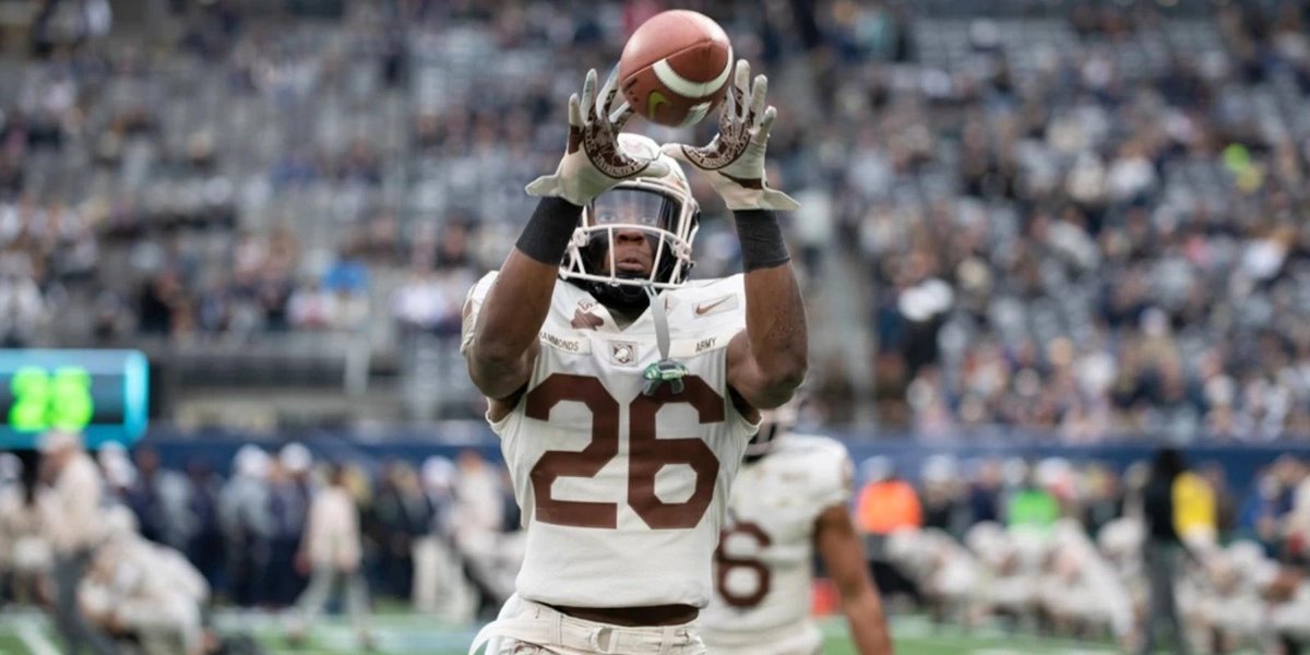 Army football player catching a pass during Army-Navy game on a stadium field