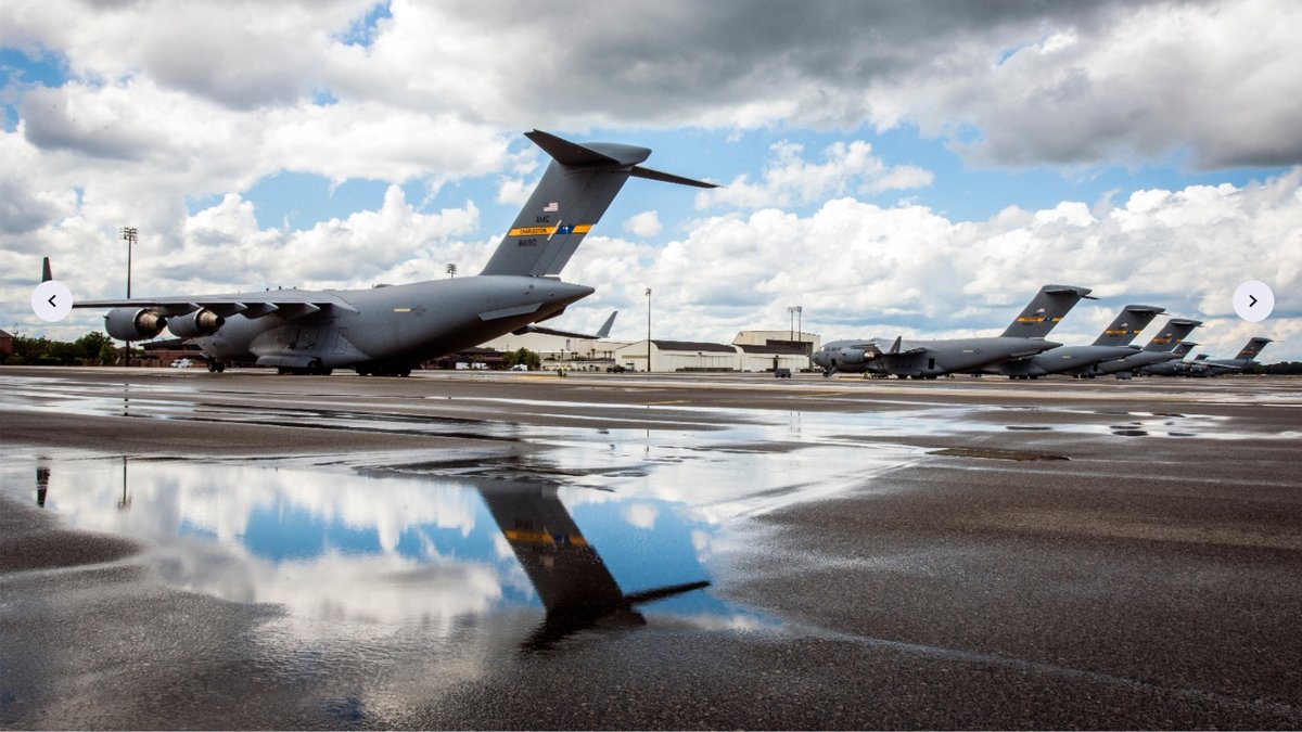 Airfield with several military tankers and hangars.