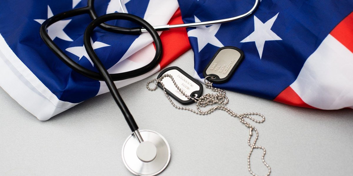 Stethoscope and military dog tags on American flag background
