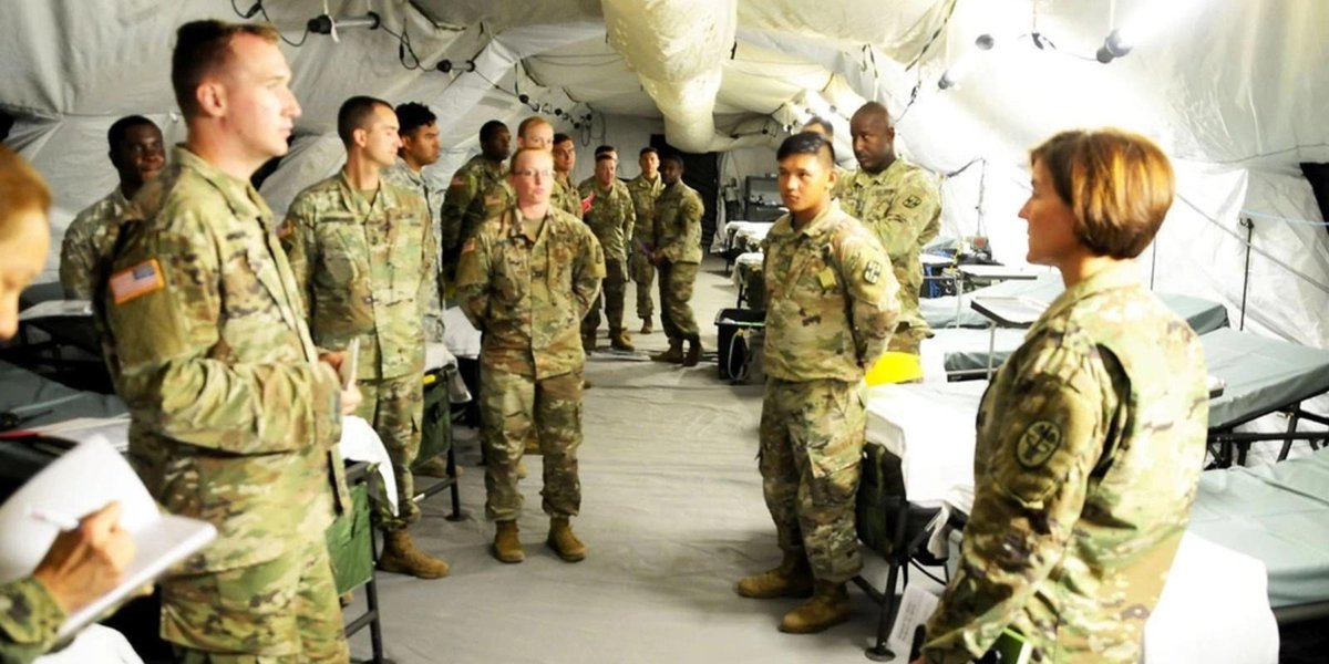 Army personnel in discussion inside a military tent, related to deployment bonus policies.
