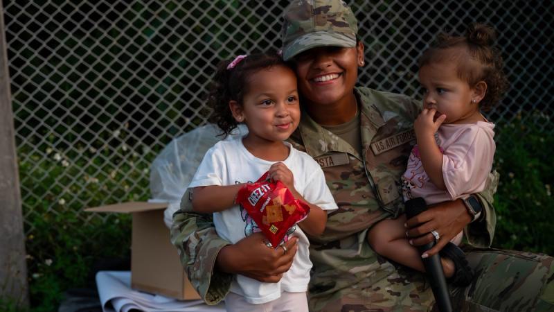U.S. Air Force Senior Airman Deneesha Acosta, 18th Maintenance Group religious affairs journeyman, holds her daughters during the 18th MXG Kids Bootcamp at Kadena Air Base, Japan, Sept. 26, 2024.