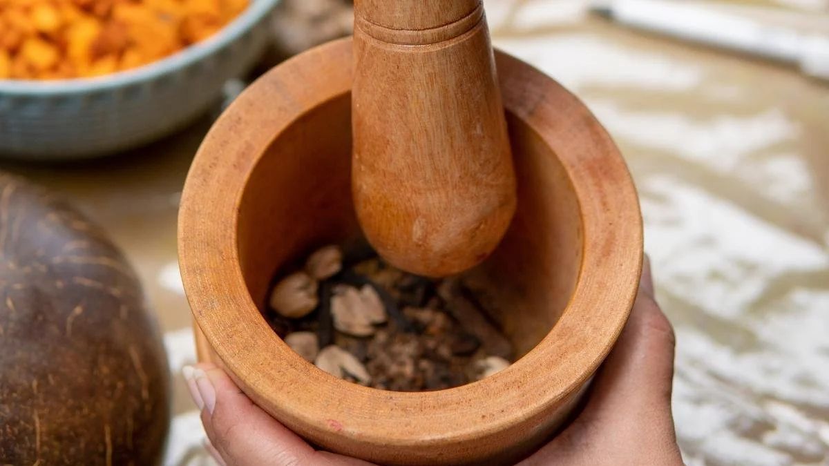 Dried iboga is crushed with a mortar and pestle.