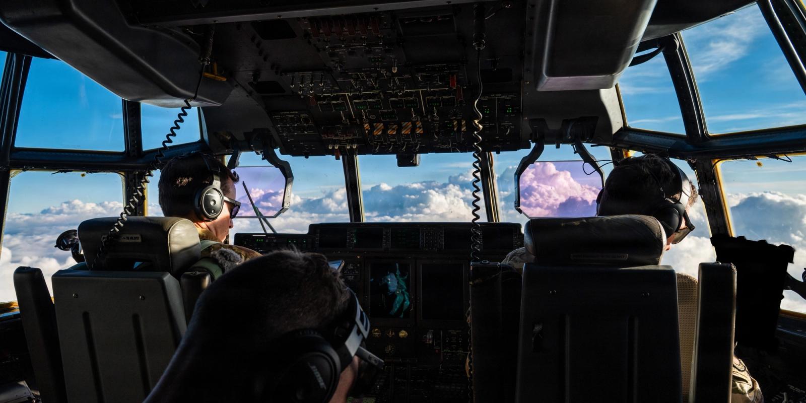 Two male pilots in flight in a cockpit.