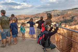 Families take pictures in a viewing area in a picturesque canyon.