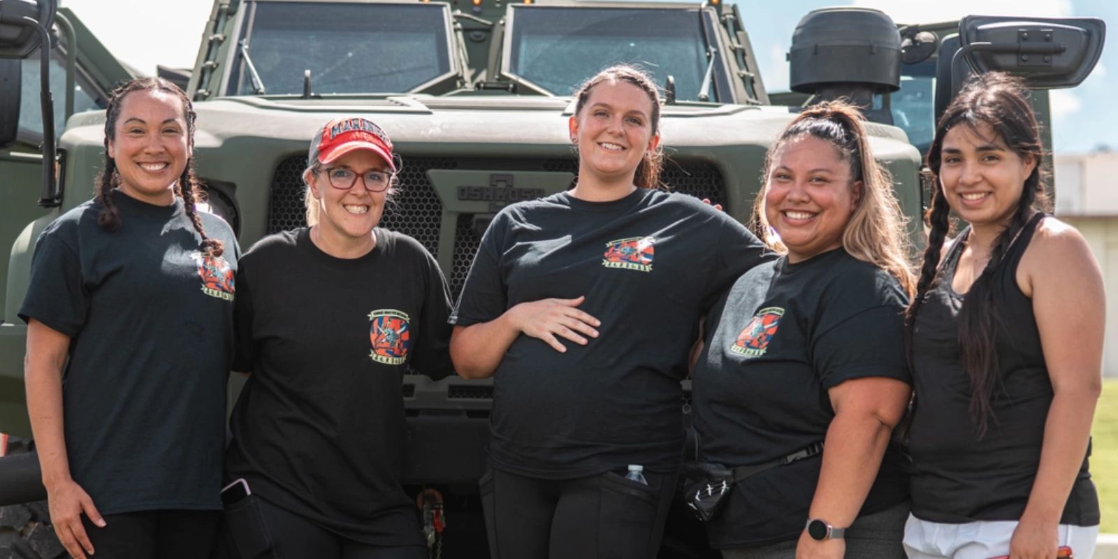 U.S. Marine Corps spouses pose for a photo in front of a Joint Light Tactical Vehicle during a Spouse Warrior Day at Camp Foster, Okinawa, Japan.