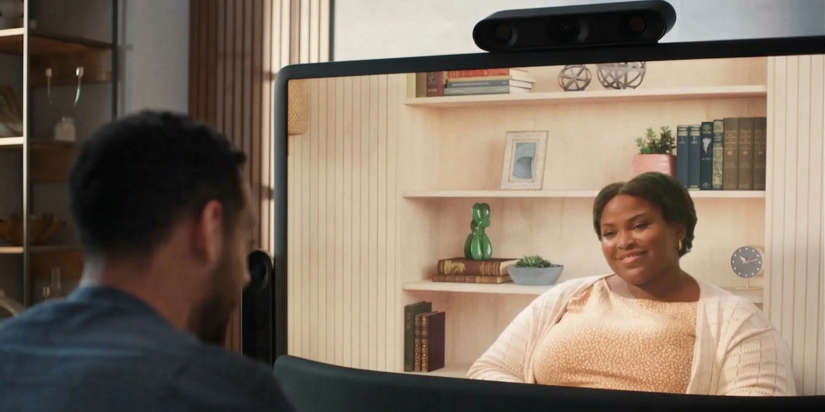 Man talking to a woman on a 3D screen.