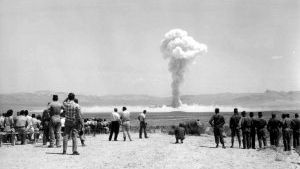 Vintage black-and-white picture of soldiers watching an A-bomb test in Nevada.