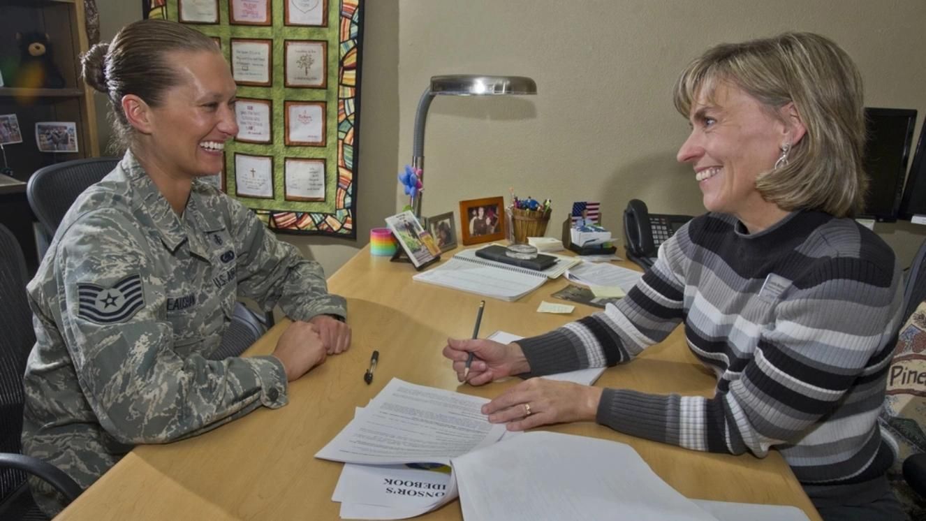 Air Force member discussing job transition with career counselor at an office desk.