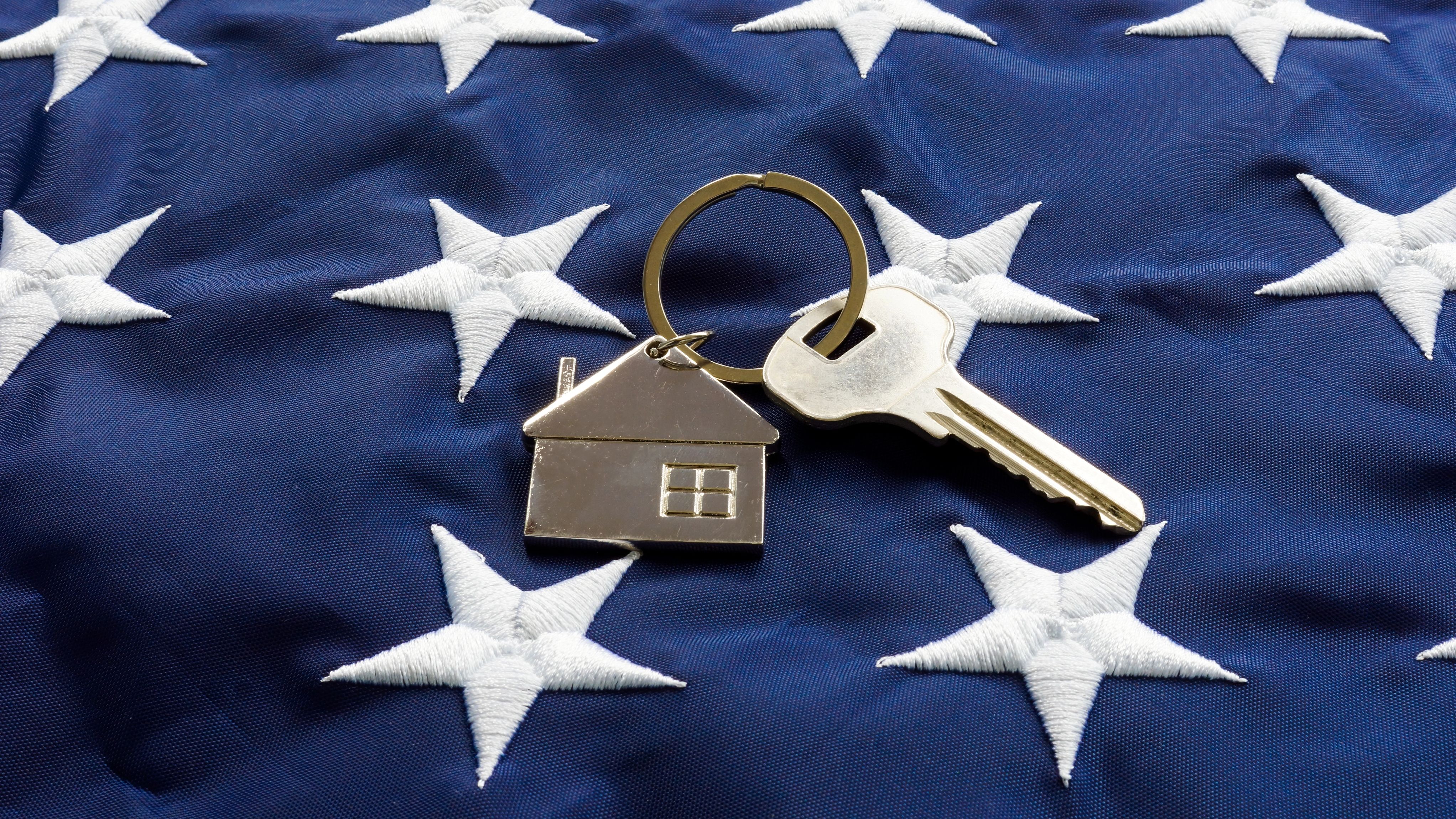 Still life of House-shaped key fob and key on a flag.