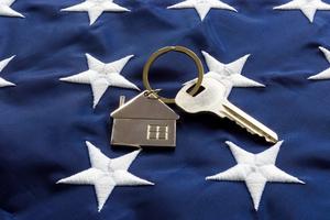 Still life of House-shaped key fob and key on a flag.