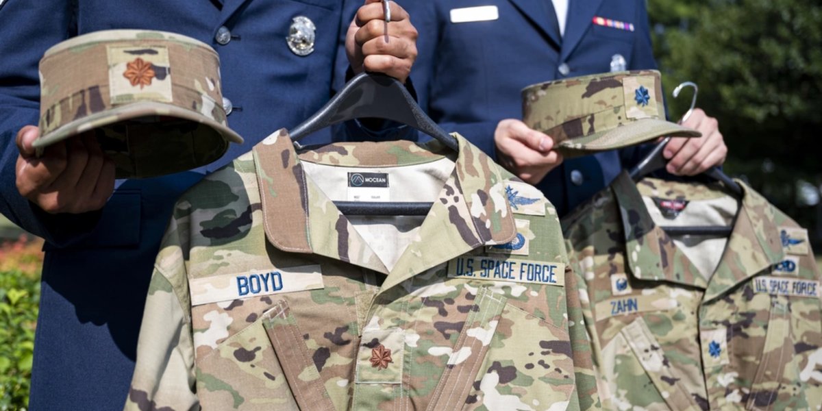 Two members of the United States Honor Guard hold the new uniforms for Lt. Col. Nathan Zahn and Maj. Justin Boyd prior to their transfer into the United States Space Force.