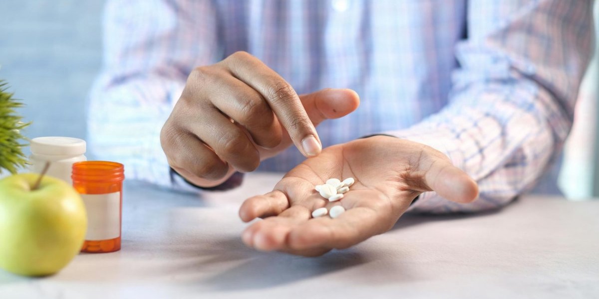 One hand sorts pills in another hand.