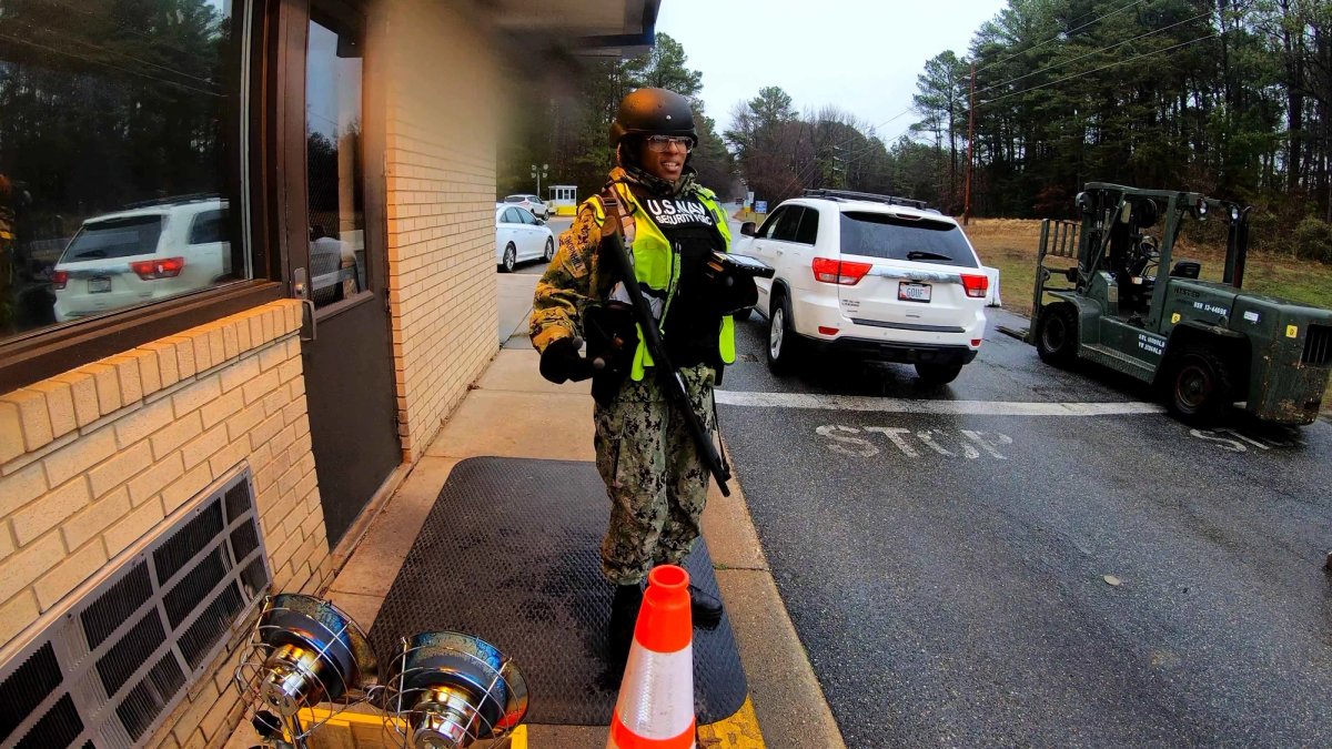 A uniformed guard at a gate at a base.