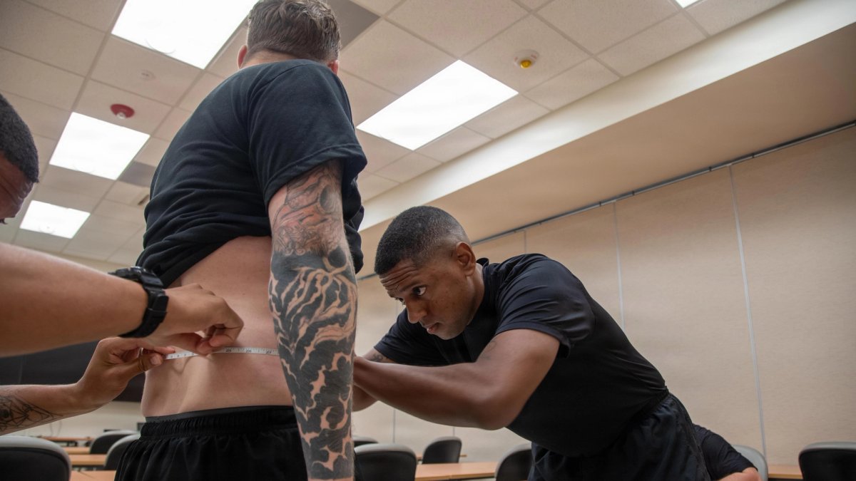 A serviceperson gets measured to test for body requirements.