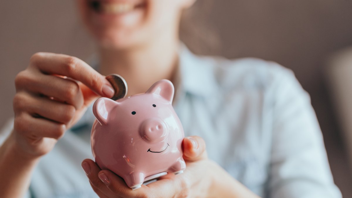 Military spouse saving money, represented by putting savings in a piggy bank.