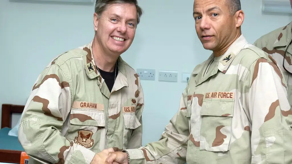 A uniformed Lindsey Graham shakes the hand of another airman.