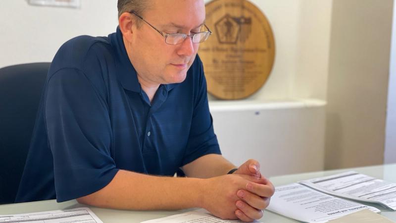 Andrew Strouse, the Garrison Casualty Manager and Retirement Services Officer, looks over paperwork that goes into survivor packets.
