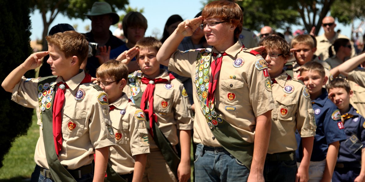 Boy scouts stand in formation and salute.