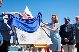 Officials witness the unveiling of a plaque.