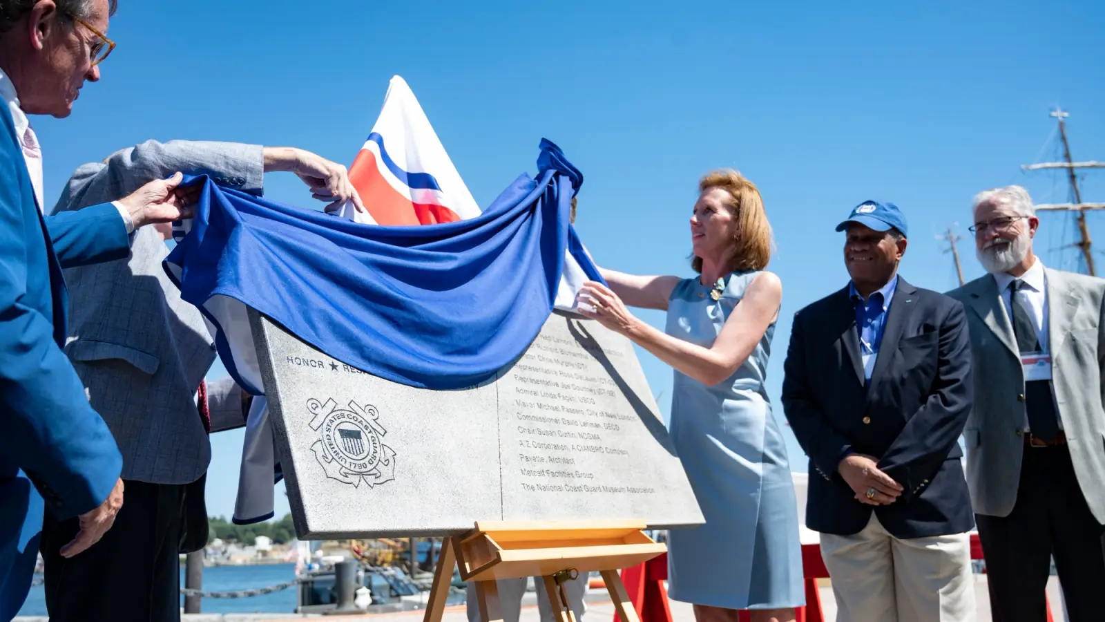 Officials witness the unveiling of a plaque.