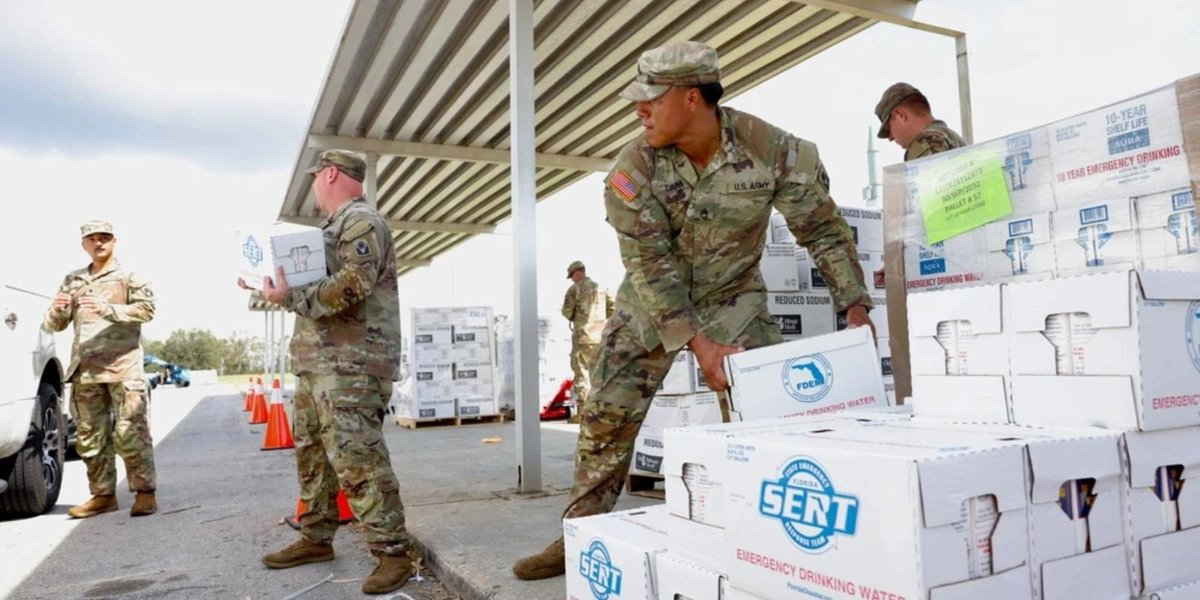Army soldiers distributing emergency water supplies at Fort Bragg during Hurricane Helene relief efforts.