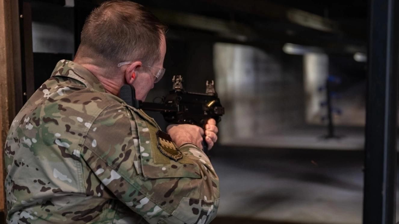 Veteran in camouflage using a shooting range for firearm safety practice.