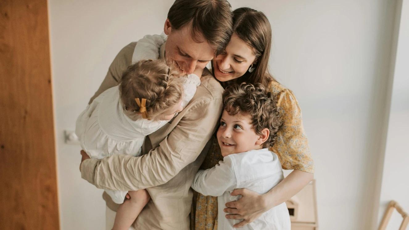 Military family hugging in living room before PCS move.