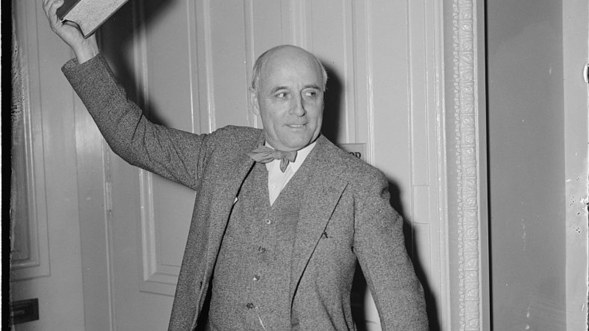 Rep Andrew May holding a book.