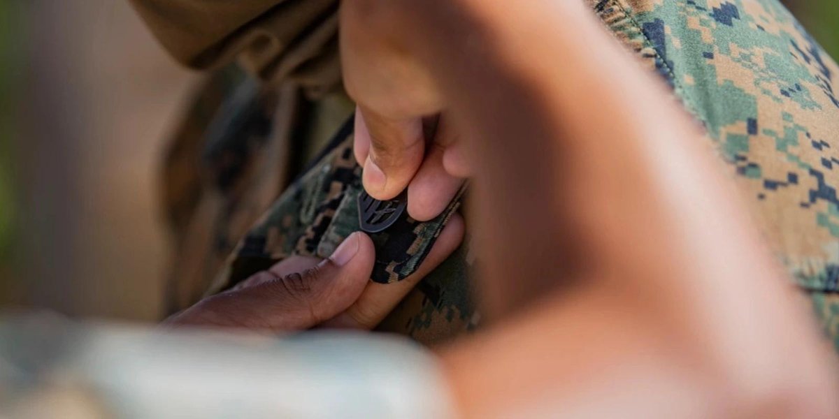 Marine Corps officer receiving a promotion pin on camouflage uniform